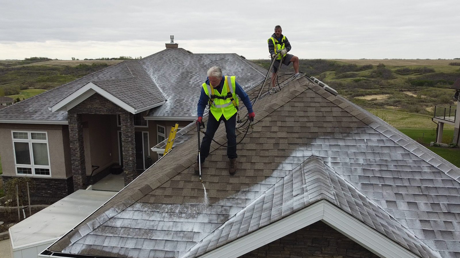 Two workers cleaning large house roof-Roof Rejuvenate pros